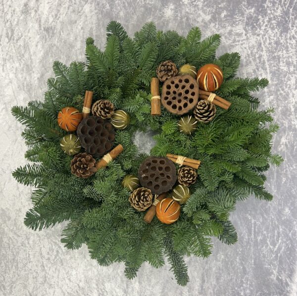 Festive Spice Fresh Christmas Wreath. The Kilted Christmas Tree Co Festive Spice Fresh Christmas Wreath is a fantastic mixture of dried fruit, lotus heads, cinnamon sticks, and cones. Its Highland Scottish noble fir delivers a beautiful scent to enhance your festive home. Handmade in Kinross The sizing relates to the circumference of the metal wreath ring, add approximately another inch on either side for the lush foliage. Sizing may vary slightly.